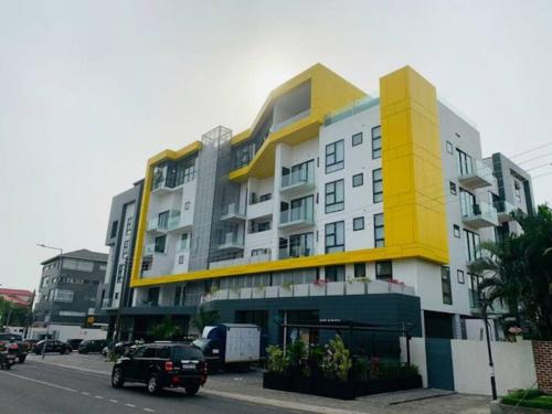 a large yellow and white building on a city street at Luxury Labone Edge 2-bedroom apartment in Accra - FiveHills homes in Accra