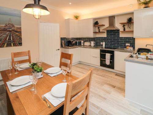 a kitchen and dining room with a wooden table and chairs at 10 Walton Terrace in Guisborough