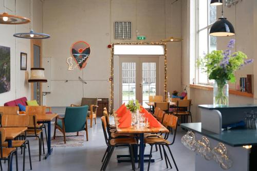 a dining room with tables and chairs and a mirror at Flørli 4444 Hostel in Fløyrli