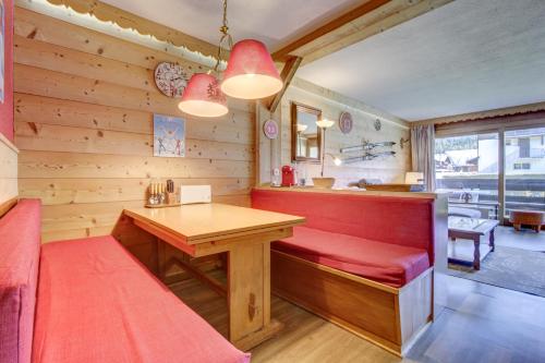 un restaurant avec un banc rouge et une table dans l'établissement CHEVRULS A4, à Morzine