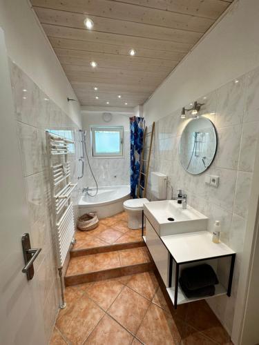 uma casa de banho com um lavatório, uma banheira e um WC. em Villa Anton em Murnau am Staffelsee