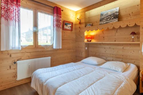 um quarto com uma cama grande numa parede de madeira em CHEVRULS A4 em Morzine