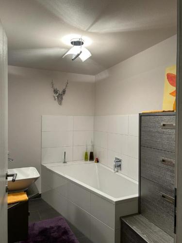 łazienka z dużą białą wanną i umywalką w obiekcie Grossbergblick w mieście Filzmoos