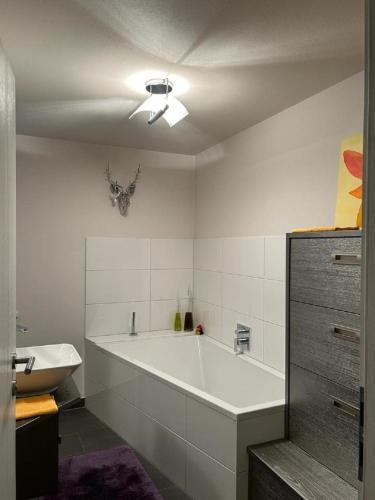 a bathroom with a large white tub and a sink at Grossbergblick in Filzmoos