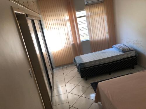 Habitación pequeña con 2 camas y ventana en Hostel Vo Mariana, en Goiânia