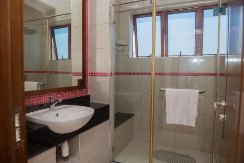 a bathroom with a sink and a glass shower at Njakaimba Beachfront Villa. in Mombasa