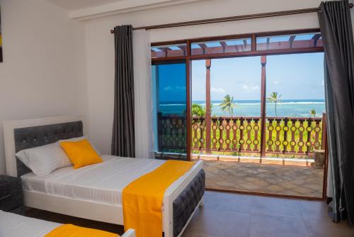 a bedroom with a bed and a view of the ocean at Njakaimba Beachfront Villa. in Mombasa
