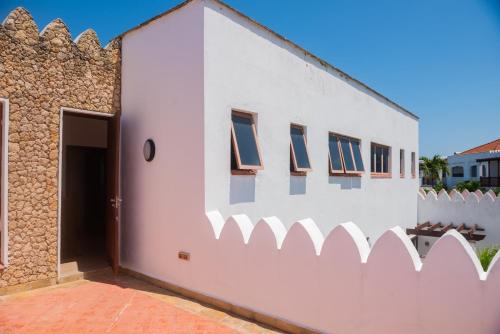 a white building with windows on the side of it at Njakaimba Beachfront Villa. in Mombasa