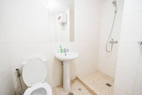 a bathroom with a toilet and a sink and a shower at Comfy Casa in Jakarta