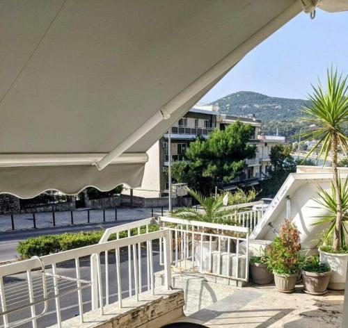 a balcony with a white railing and some plants at Emanuela SunnySide in Kavála