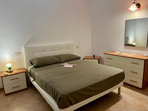 1 dormitorio con 1 cama grande y 2 mesitas de noche en Oliveri nuovo appartamento 5 posti letto più posto auto privato, en Oliveri