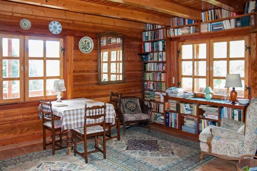 a dining room with a table and chairs and bookshelves at Kalinowa Chata in Wierchomla Wielka