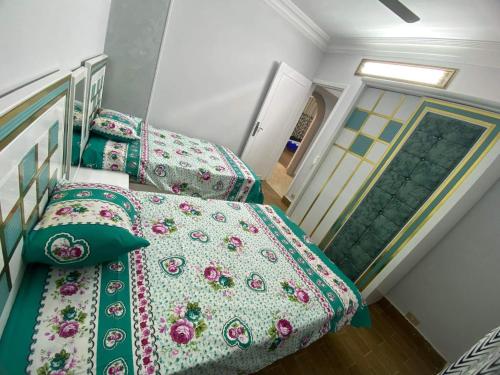 - une chambre avec 2 lits et des couettes vertes dans l'établissement شقة 9 شارع الصفاء / طه حسين / النزهة الجديدة, au Caire