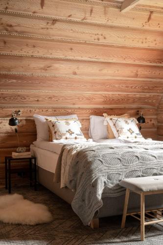 a bedroom with a bed and a wooden wall at Dom Górski 878 mnpm in Zakopane