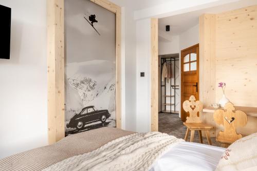 a bedroom with a bed and a car picture on the wall at Dom Górski 878 mnpm in Zakopane
