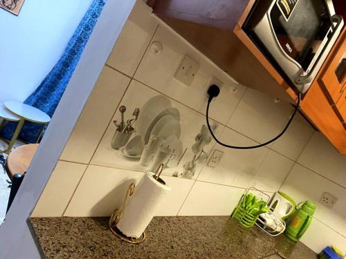 uma bancada de cozinha com um lavatório e uma bancada em Cottage with AC em Kisumu