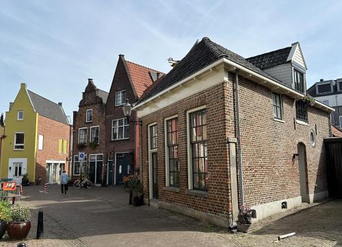 um antigo edifício de tijolos numa rua com edifícios em Luxe Loft in Historisch Pand in Walstraat Deventer em Deventer