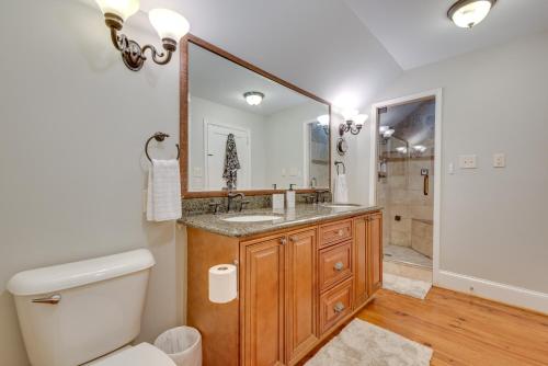 a bathroom with a sink and a toilet and a mirror at Welcoming Norcross Cottage with Deck and Shared Grill! in Norcross