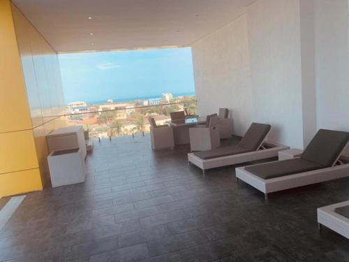 a room with chairs and tables and a large window at Luxury Labone Edge 2-bedroom apartment in Accra - FiveHills homes in Accra