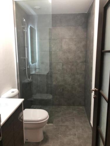 a bathroom with a shower with a toilet and a sink at Luxury Labone Edge 2-bedroom apartment in Accra - FiveHills homes in Accra