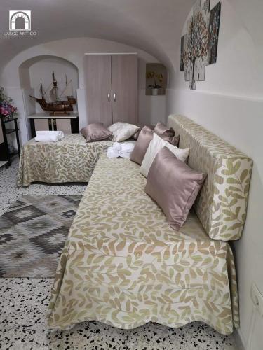 a bedroom with two beds and a couch with pillows at Arco Antico in Grassano