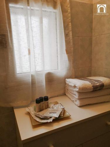 a bathroom counter with a window and towels on it at Arco Antico in Grassano