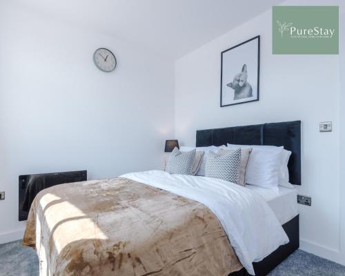 a bedroom with a large bed with a wooden headboard at Stunning Central House By PureStay Short Lets & Serviced Accommodation Birmingham in Birmingham