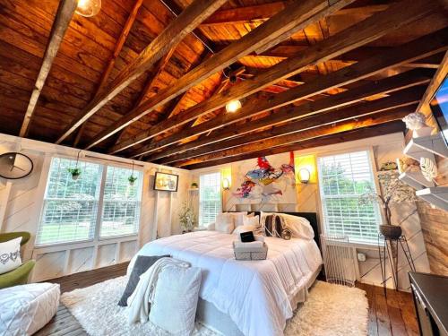 - une chambre avec un grand lit dans une pièce dotée de plafonds en bois dans l'établissement Tiny House Hideaway with King Bed, à Cape Charles