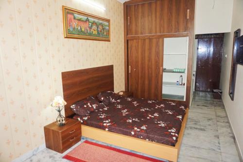 ein kleines Schlafzimmer mit einem Bett und einer Vase aus Blumen in der Unterkunft The Nest in Jaipur