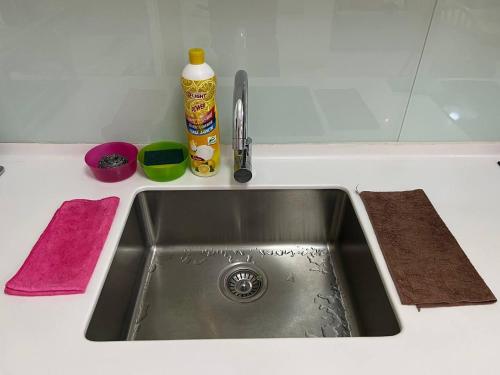 a kitchen counter with a sink and two towels at Teega Suites Seaview by VDO Homestay in Nusajaya