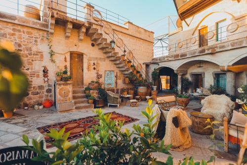 an outdoor patio with furniture and a staircase in a building at La maison de Şişik in Uçhisar