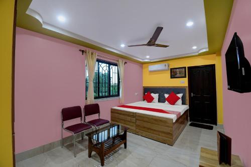 加爾各答的住宿－Hotel Mahal And Restaurant Kanchrapara，一间卧室配有一张床和两把椅子