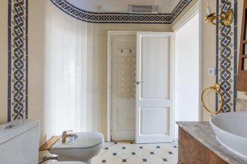 a bathroom with a toilet and a sink and a door at Lodging Apartments Paseo de Gracia in Barcelona