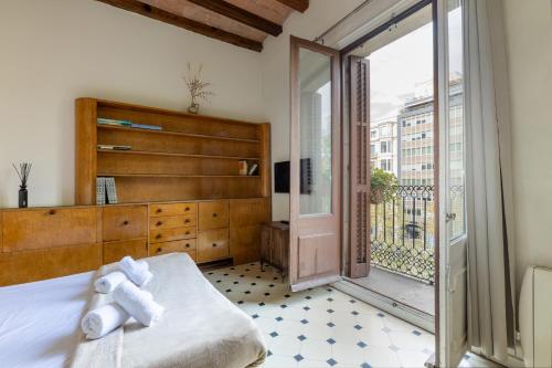 a bedroom with a bed and a sliding glass door at Lodging Apartments Paseo de Gracia in Barcelona