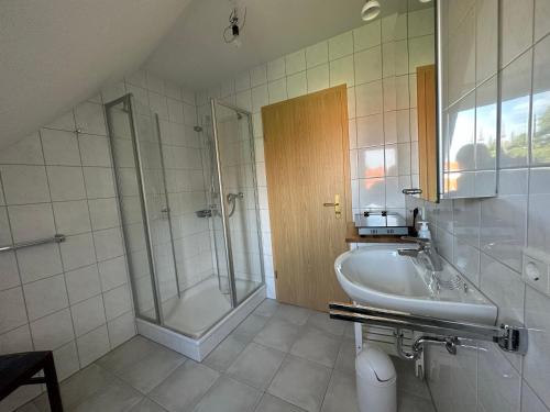 y baño con ducha, lavabo y bañera. en Mitten in Detmold mit schönem Ausblick, en Detmold