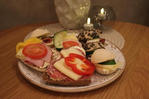 a plate of sandwiches with cheese and vegetables on a table at Hotell Rådhuset in Lidköping