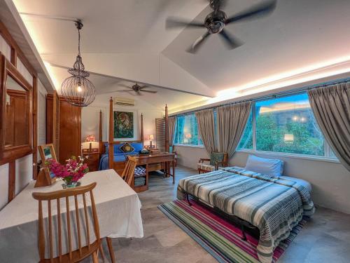 Sinurambi Bed & Breakfast - Mills Residence في Penampang: غرفة نوم بسرير وطاولة ونافذة
