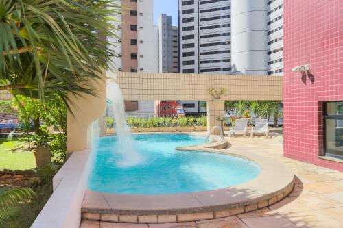 a swimming pool with a fountain in a city at Tulip Inn Fortaleza in Fortaleza