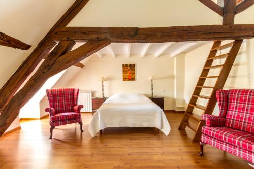 a bedroom with a bed and two chairs at Le Fassardy in Châteauroux