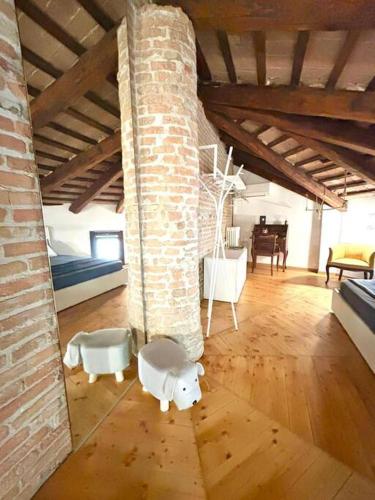 a room with a brick wall and a room with a couch at Chiesetta abside ex seminario -jvapartmentRovigo in Rovigo