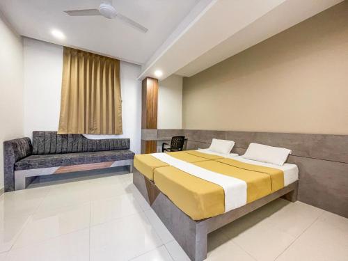 a bedroom with a bed and a couch in it at Hari Om Residency in Bhuj