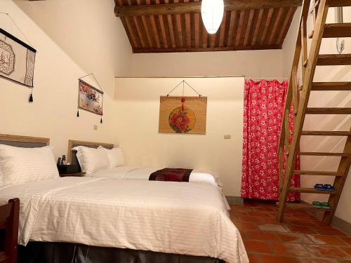 a bedroom with two beds and a red curtain at Yong Le Homestay in Jincheng
