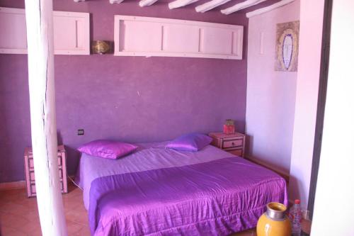 a bedroom with a purple bed with purple sheets at VILLA CATHERINE MARRAKECH in Marrakech