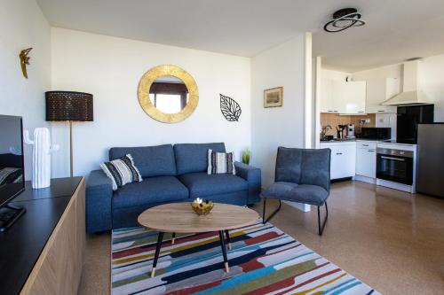 un salon avec un canapé bleu et une table dans l'établissement LE DANVIN - Spacieux Studio 4 pers - Grand balcon - A 150 m de la Plage, à Berck-sur-Mer