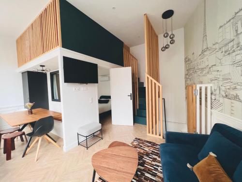 un salon avec un canapé bleu et une table dans l'établissement Montmartre Marvel! Designer Apartment near metro, à Paris