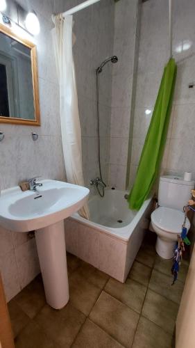 a bathroom with a sink and a tub and a toilet at Pension Suiza in Reus