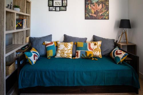 ein Sofa mit Kissen darauf im Wohnzimmer in der Unterkunft LE DANVIN - Spacieux Studio 4 pers - Grand balcon - A 150 m de la Plage in Berck-sur-Mer