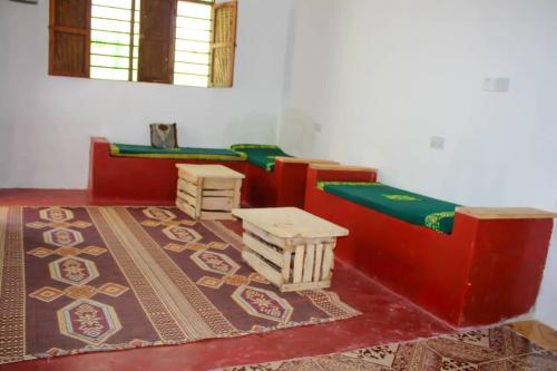 une chambre avec deux lits et deux tables dans l'établissement Pamoja Beach Stays Hotel in Jambiani, à Jambiani