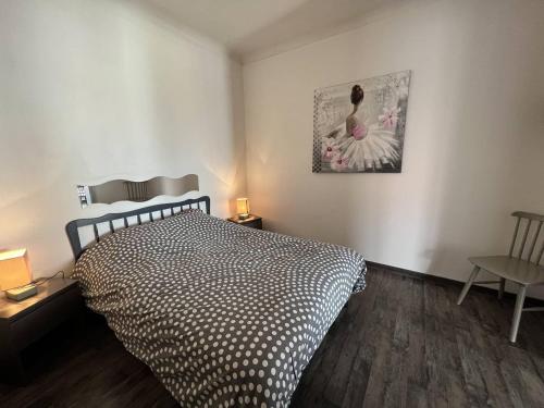 une chambre avec un lit et un tableau au mur dans l'établissement Grand appartement avec terrasse et piscine privée, à Saint Pierre La Mer