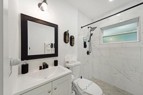 Baño blanco con lavabo y espejo en Peaceful Retreat By Pmi, en Fort Lauderdale